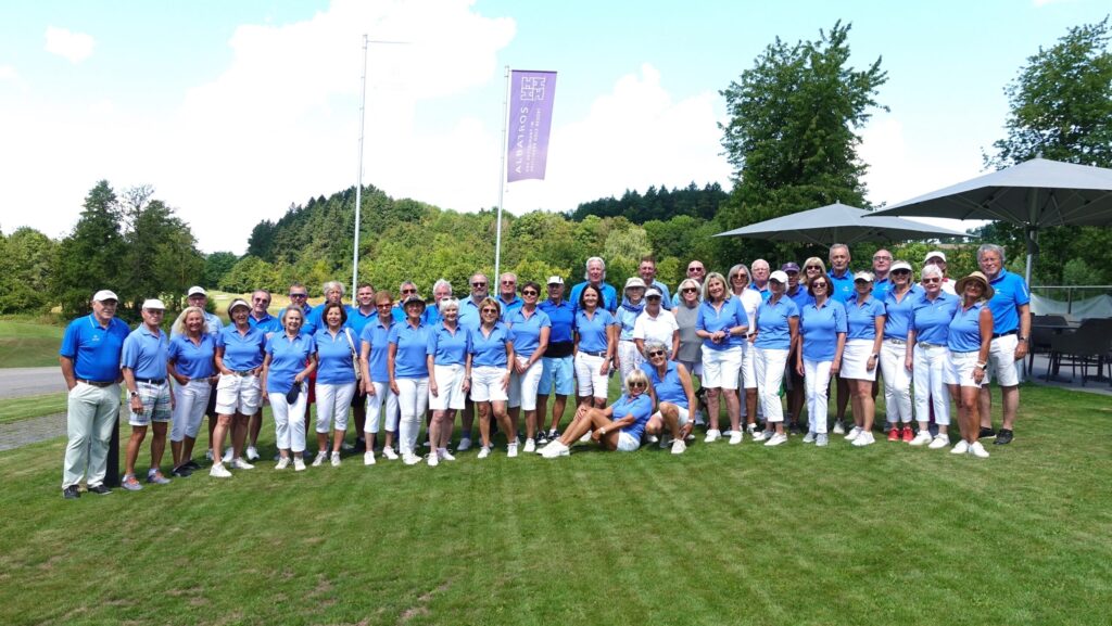 Gruppenfoto der Teilnehmenden in Blau und Weiß auf dem Rasen vor dem Clubhaus