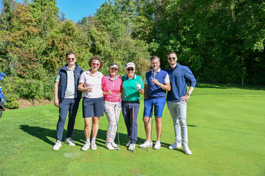 Flight mit Weingläsern auf dem Fairway vor Bäumen
