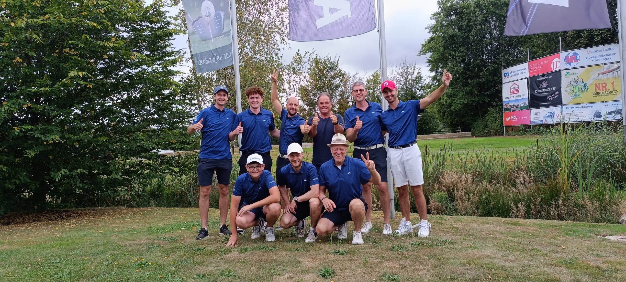Jubelnde Herrenmannschaft in blauen Poloshirts nach dem Aufstieg