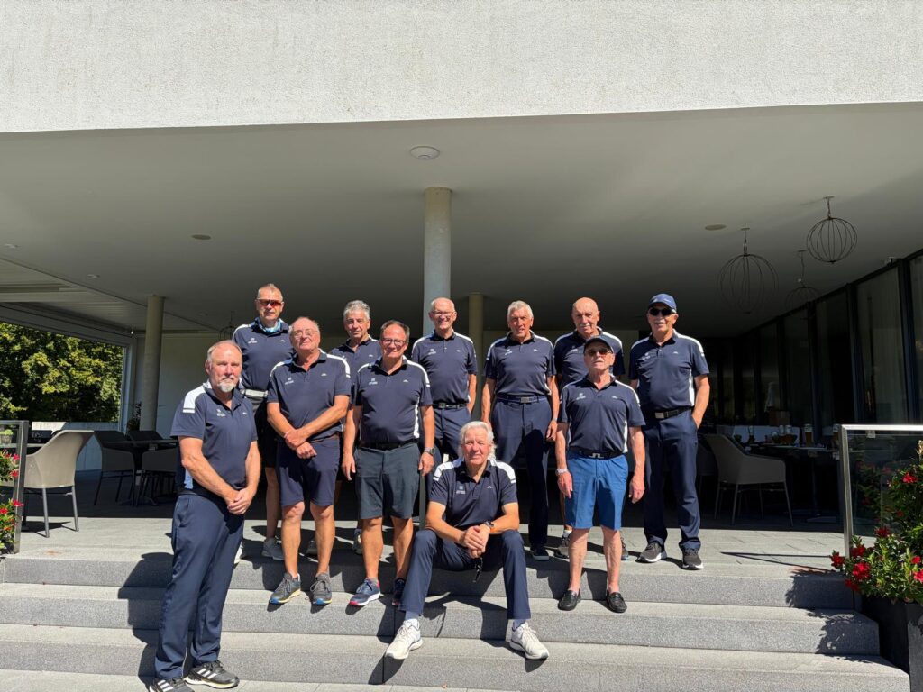 AK-65-Mannschaft in dunkelblauen Poloshirts auf der Treppe vor dem Clubhaus