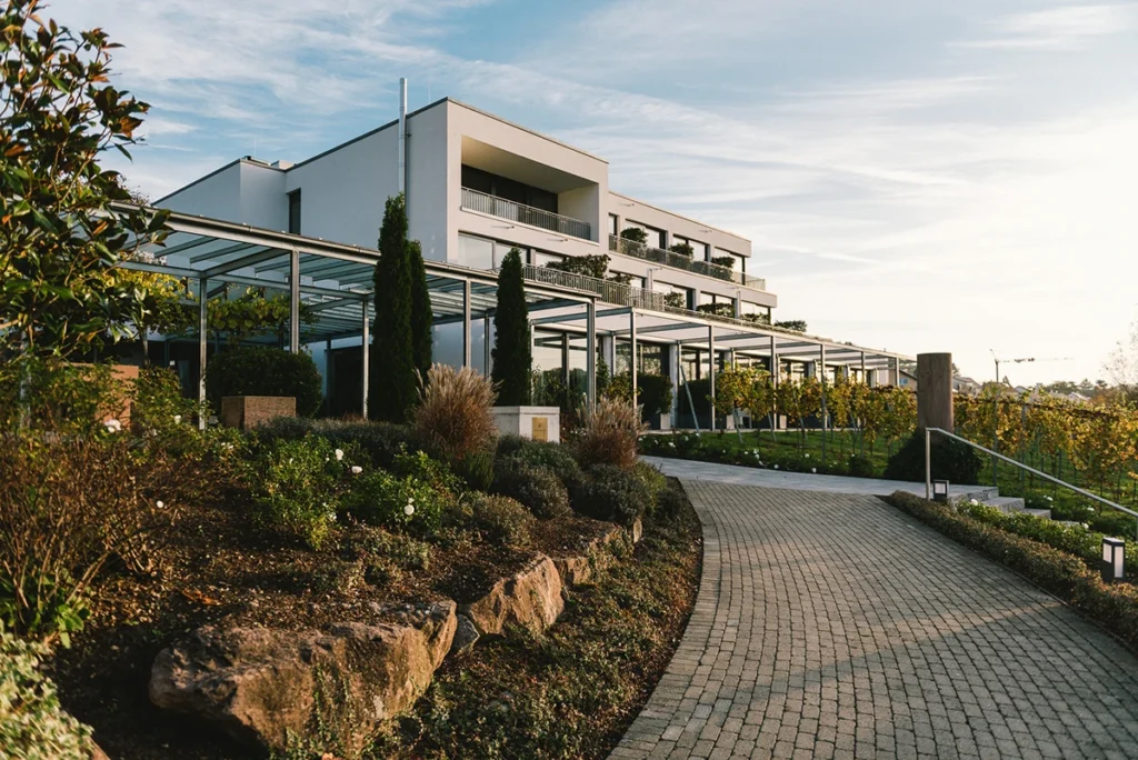 Heitlinger Hof mit Pergola, gepflastertem Weg und Garten in der Abendsonne